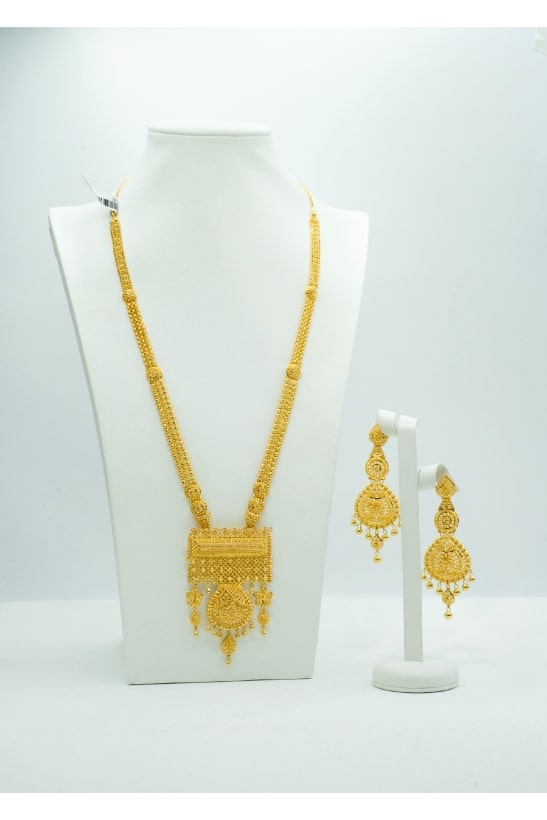 Radiant long gold necklace with a heavy pendant and matching long earrings