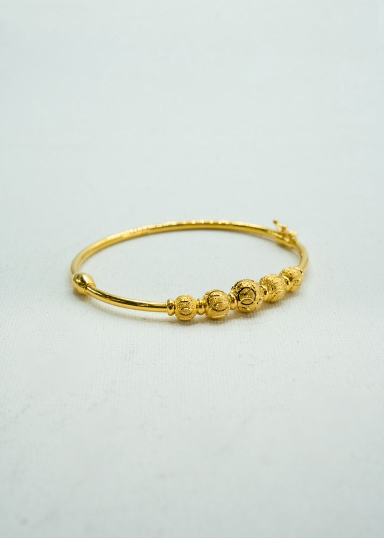 Yellow-gold beaded kada with fine carvings and regal finish