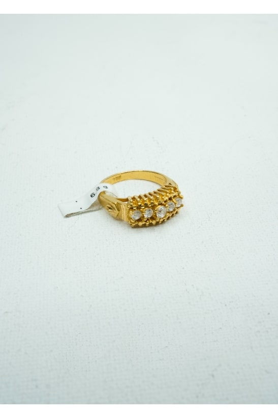 Yellow gold ring with five small round diamonds set into a gold claw-shape center.