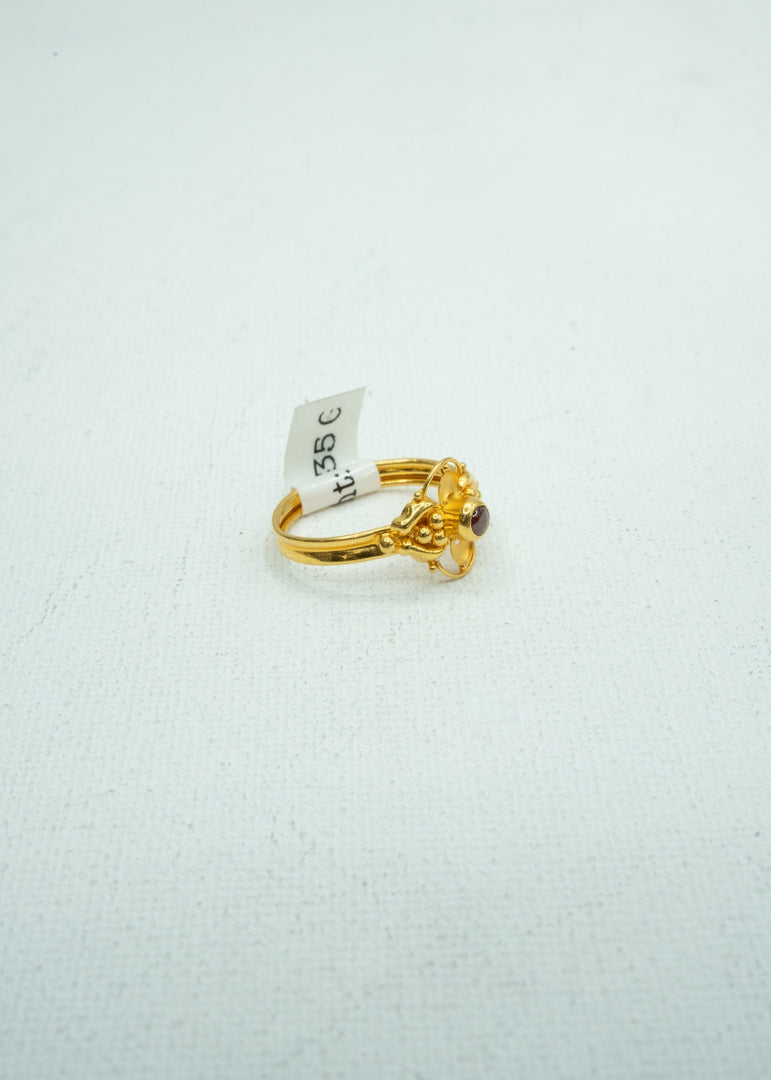 Dainty gold ring with self-carvings and small coloured stone centre.