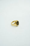 Hexagon-shaped black stone signet ring in gold with carvings on the band