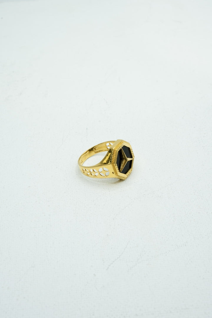 Hexagon-shaped black stone signet ring in gold with carvings on the band