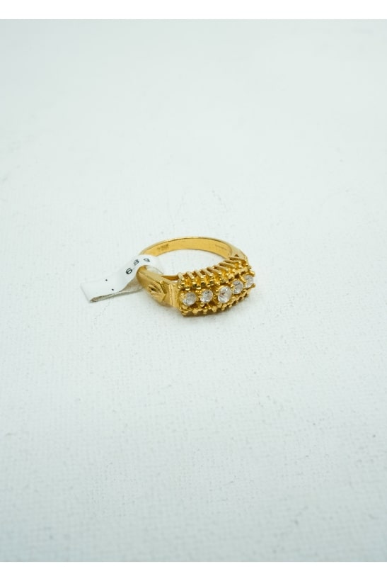 Yellow gold ring with five small round diamonds set into a gold claw-shape center.